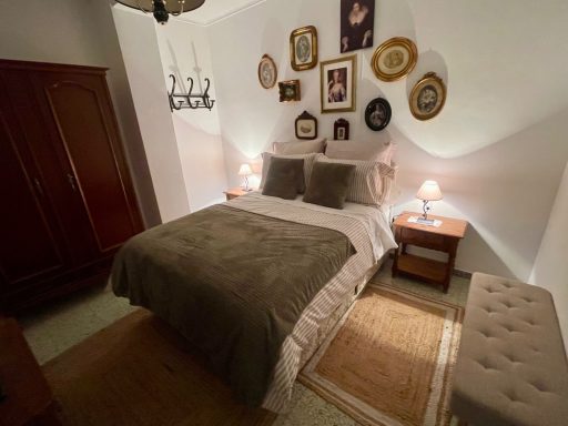 Habitación acogedora con cama doble, decoraciones en la pared y luz suave.
